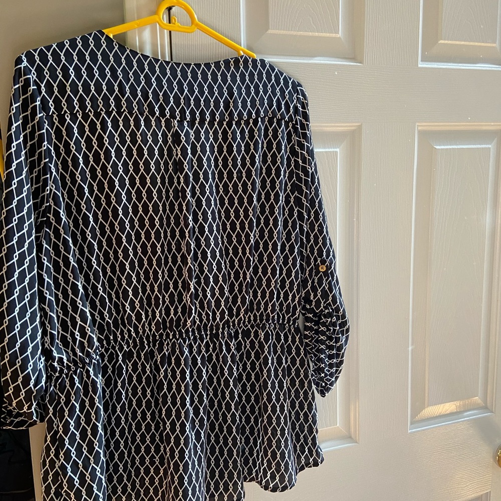 Black blouse with white details. Front has a zipper.